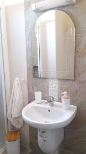 a bathroom with a white sink and a mirror at Appart. Luxueux avec piscine, cosy, bien situé in Bouznika