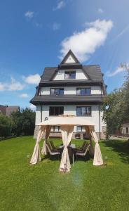 a house with a gazebo in front of it at Czekoladowa Willa in Białka Tatrzanska