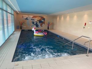 DOMITYS LES NOTES FLORALES في Combs-la-Ville: حمام سباحة مكرونه حمام سباحة في مبنى