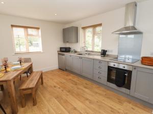 a kitchen with stainless steel appliances and a wooden table at The New Build in Louth