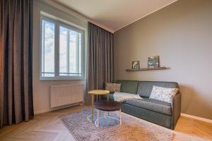 uma sala de estar com um sofá e uma mesa em NinetyNine Augsburg em Augsburg