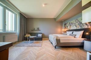 a bedroom with a king sized bed and a couch at NinetyNine Augsburg in Augsburg