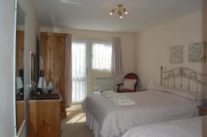 セント・マーティン・ガーンジーにあるLa Micheleのベッド2台とテレビのある寝室