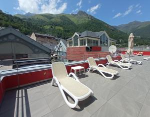 a row of chairs and umbrellas on a roof at Garden & City Cauterets Balneo in Cauterets