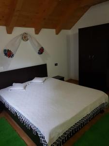 a bedroom with a large white bed in a room at Cabana Alexandra in Moisei +78 photos