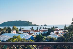 a city with houses and the ocean in the background at Iberostar Waves Slavija in Budva