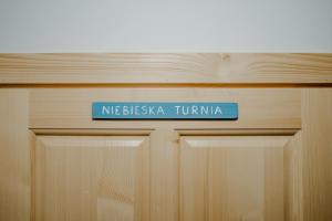 a blue sign on top of a wooden door at Osada Witów - apartament „Niebieska Turnia” in Witów