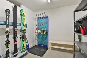 une chambre avec des skis et des snowboards suspendus sur un mur dans l'établissement Garni Maso San Michele, à Cavalese