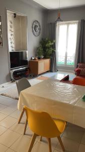 a living room with a table and chairs and a television at Appartement au centre de Nice in Nice