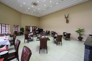 a dining room with tables and chairs in a restaurant at Big Valley Game Lodge in Lobatse