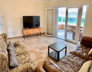 a living room with a couch and a flat screen tv at Sea Dream House Kessingland Air Manage Suffolk in Lowestoft