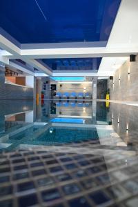 a swimming pool in a building with a blue ceiling at Apart & Spa Zoned in Kopaonik