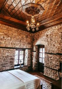een slaapkamer met een groot bed en een kroonluchter bij Beratino Hotel in Berat