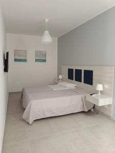 ein weißes Schlafzimmer mit einem großen Bett und einer Lampe in der Unterkunft La Lume in Partanna