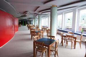 jadalnia ze stołami, krzesłami i oknami w obiekcie Rotel Inn w Pasawie