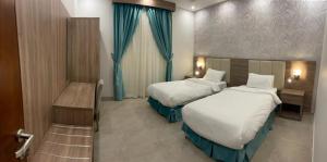 a hotel room with two beds and a window at Tu Jardin Al Harmain- تو جاردن الحرمين in Jeddah