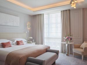 a bedroom with a bed and a chair and a window at One Aldwych in London