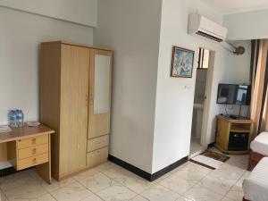 a room with a closet and a desk and a bedroom at Panama Inn Moshi in Moshi