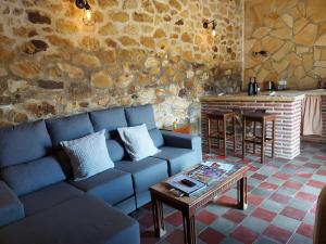 salon z niebieską kanapą i stołem w obiekcie Casas Rurales- "Casa Larios" w mieście El Colmenar