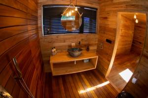 Habitación de madera con baño con lavabo. en cabañas en el árbol costa da morte, en Muxía