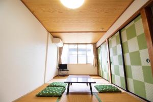 a small room with a table and green cushions at Habitacion NIIYA Mt Fuji in Fujikawaguchiko