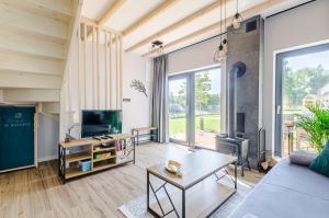 een woonkamer met een bank en een tv bij Domki w Naturze in Lubiatowo