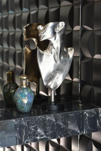 a silver dog statue on a black table with vases at Vila Reyna in Constanţa