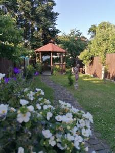 a garden with a gazebo and some white flowers at Apartmán se zahradou pro dvě osoby v turisticky oblíbené lokalitě in Weisswasser in Böhmen