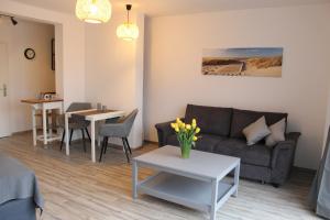 a living room with a couch and a table at Ferienwohnungen in ausgebauter Scheune mit Ostseenähe in Zarnekow