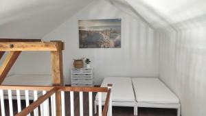 a small room with a bed and a ladder at Ferienwohnungen in ausgebauter Scheune mit Ostseenähe in Zarnekow