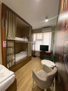 a room with bunk beds and a table and a chair at Loft Host Yerevan in Yerevan