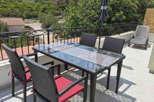 a glass table and chairs on a balcony at Deluxe apartman “ Koromačna” in Korčula