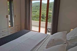 Schlafzimmer mit einem Bett und Blick auf einen Balkon in der Unterkunft Deluxe apartman “ Koromačna” in Korčula