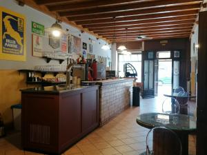 HOTEL FIORE & Fiocchi في Podenzano: مطبخ المطعم مع كونتر وطاولة