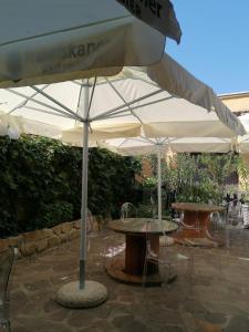 HOTEL FIORE & Fiocchi في Podenzano: طاولتين ومظلة على الفناء