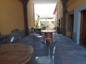 a patio with tables and chairs and an umbrella at HOTEL FIORE & Fiocchi in Podenzano