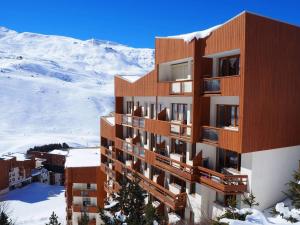 een gebouw in de sneeuw voor een berg bij travelski home select - Résidence Boedette in Les Menuires