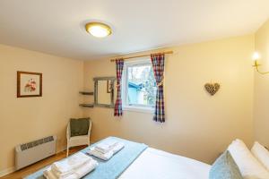 um quarto com uma cama e uma janela em Bracken Lodge 8 with Hot Tub em Belladrum
