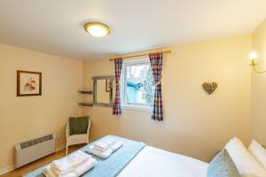 a bedroom with a bed and a window at Bracken Lodge 8 with Hot Tub in Belladrum