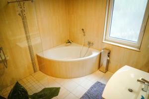 Un baño con bañera, inodoro y ventana. en Fewo Hellerswiesen Arbeiterunterkunft, en Bahretal 35 fotos más