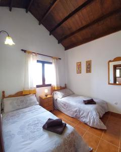sypialnia z dwoma łóżkami i oknem w obiekcie Casa Nisamarita by Sea You There Fuerteventura w mieście Lajares
