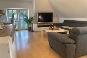 a living room with a couch and a tv at Ferienwohnung Bernsteinsucher städtische Bestlage in Ribnitz-Damgarten