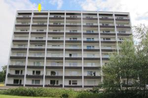 an apartment building with a yellow arrow on top of it at Dünenbake, App 62, Helgolandblick in Sankt Peter-Ording