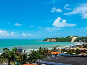 Blick auf einen Strand mit Palmen und das Meer in der Unterkunft Rede Andrade Bello Mare in Natal