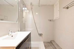 a white bathroom with a sink and a shower at Stay U-nique Apartments Estación del Norte in Barcelona