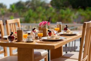 Una mesa de madera con comida y bebidas encima. en Marie Κelly Apartments, en Gouves