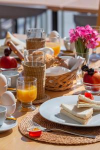 una mesa con un plato de comida y vasos de zumo de naranja en Marie Κelly Apartments, en Gouves