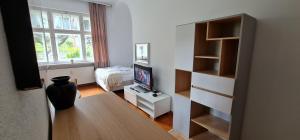a small living room with a tv and a table at Apartamenty EverySky - Konstytucji 3 go Maja 66-2 in Karpacz