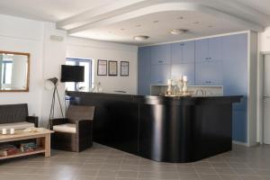 cocina con encimera negra y armarios azules en Marie Κelly Apartments, en Gouves