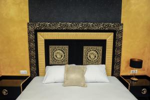 um quarto com uma cama com uma cabeceira preta e dourada em Apartmani President I em Banja Luka